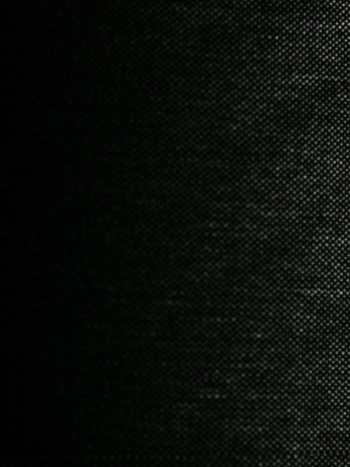 Black and white photo of a close-up of a lampshade with shadows of blinds on one side.