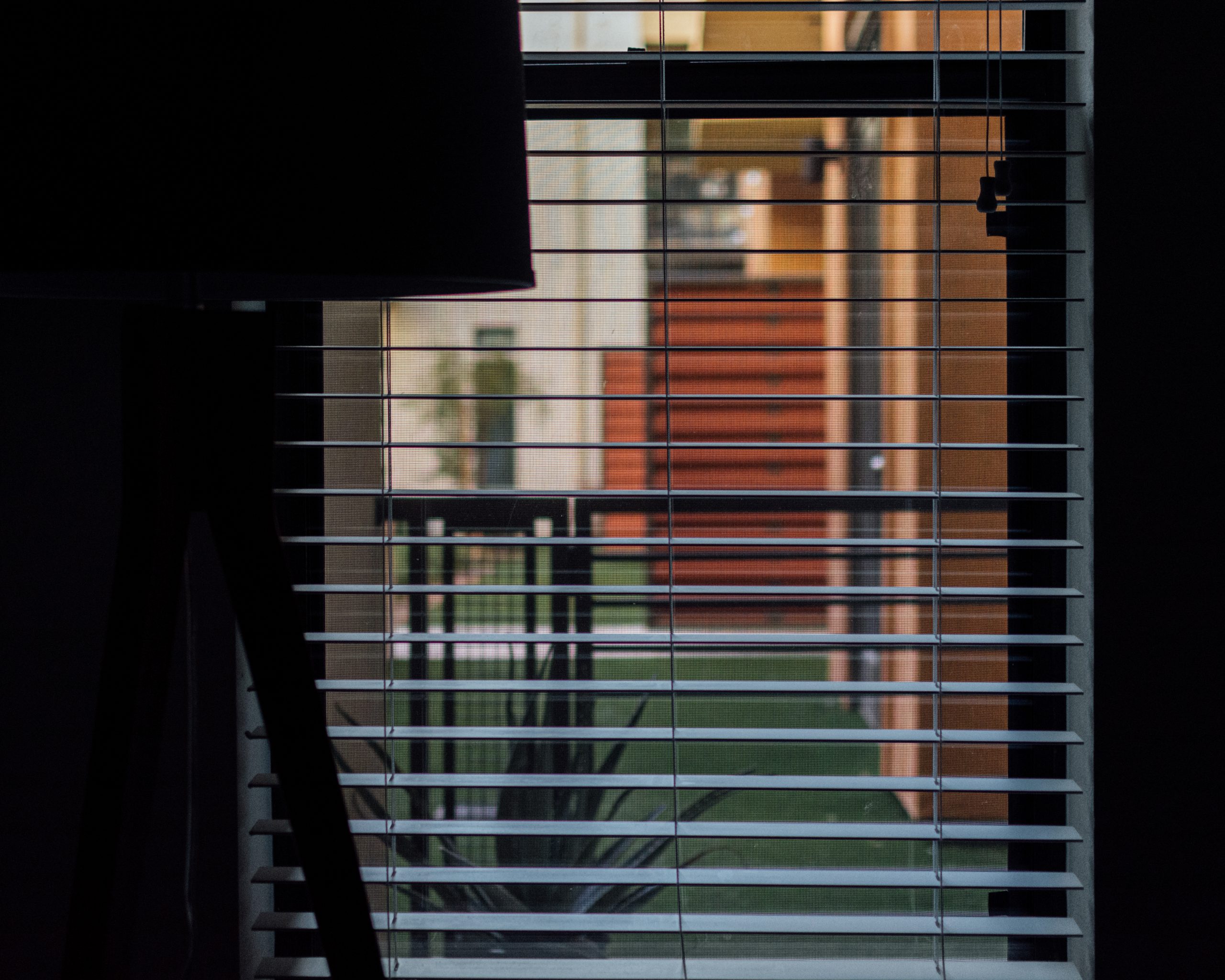 Photo of silhouette of a lamp shade looking into a courtyard.