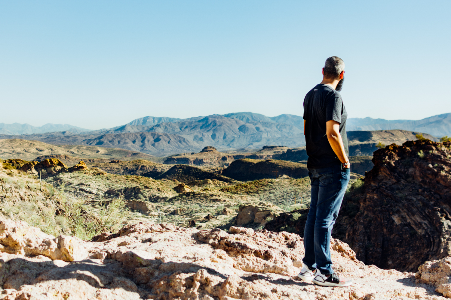 Photo of a man looking at mountains in the distance.