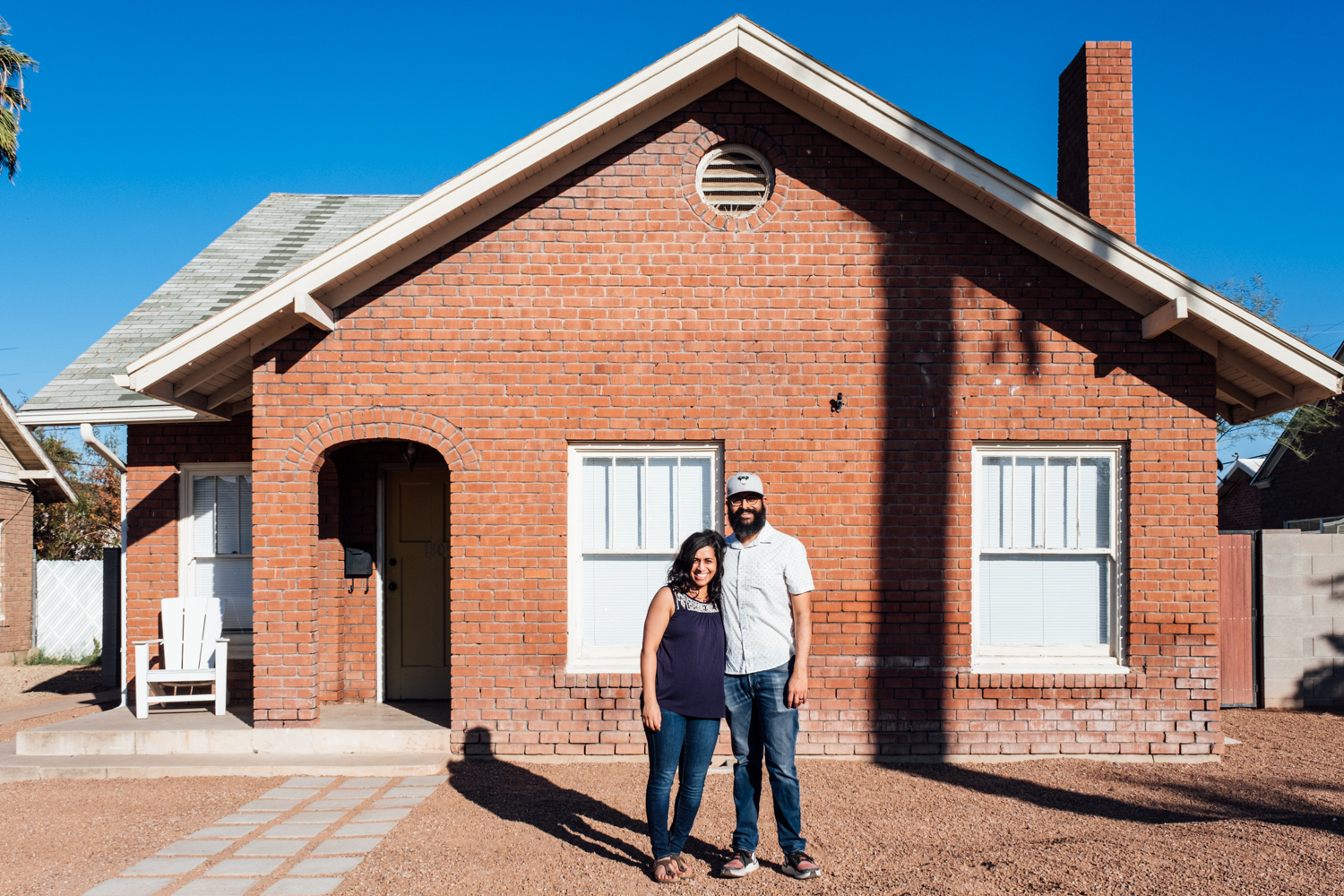 Photo of a couple standing in front of a house.