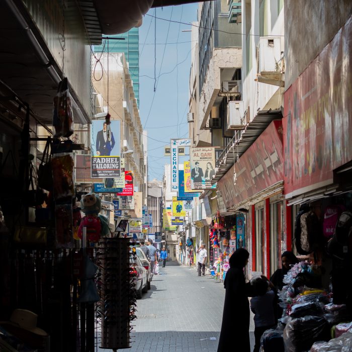 Photo of an alley in a market in Bahrain with a silhoutted woman.