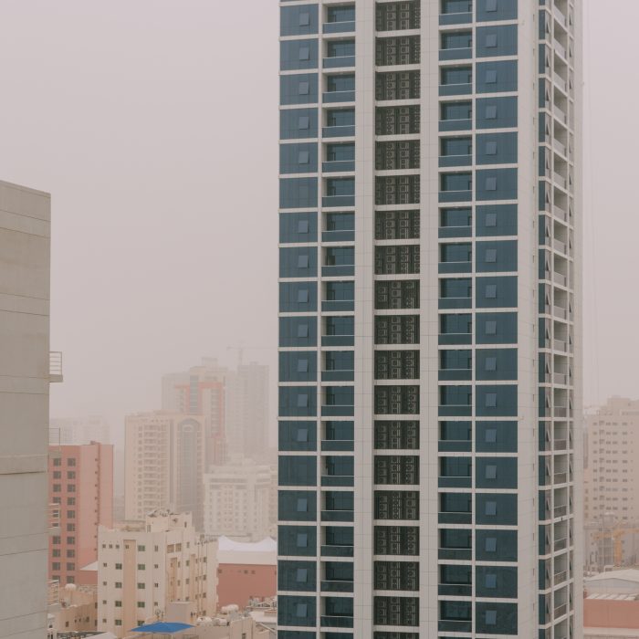Photograph of apartment buildings fading into the distance during a dust storm.