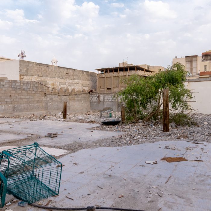 Photograph of an empty courtyard in Bahrain with an abandoned shopping cart in the foreground.