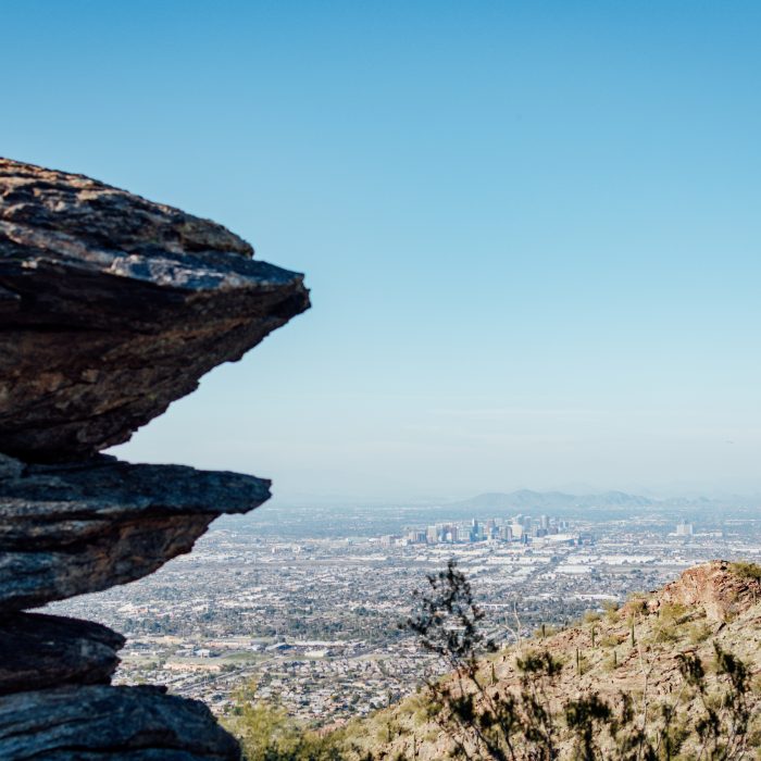 Photograph of the city of Phoenix in the distance, with views of South Mountain in the foreground.